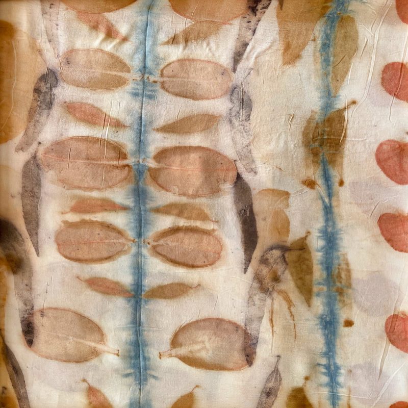 eco leaf printed and natural dyed silk satin fabric with indigo shibori in a natural dyeing workshop.